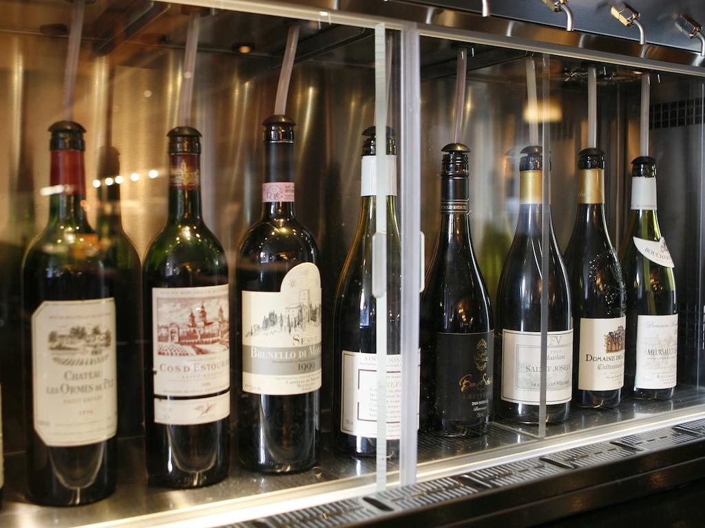 Montcalm Brewery Townhouse Hotel London Exterior photo The photo depicts a selection of wine bottles displayed in a wine fridge or cooler. The bottles are lined up behind a glass panel, showcasing various types of wine, likely including both red and white varieties. Each bottle has a distinctive label, i