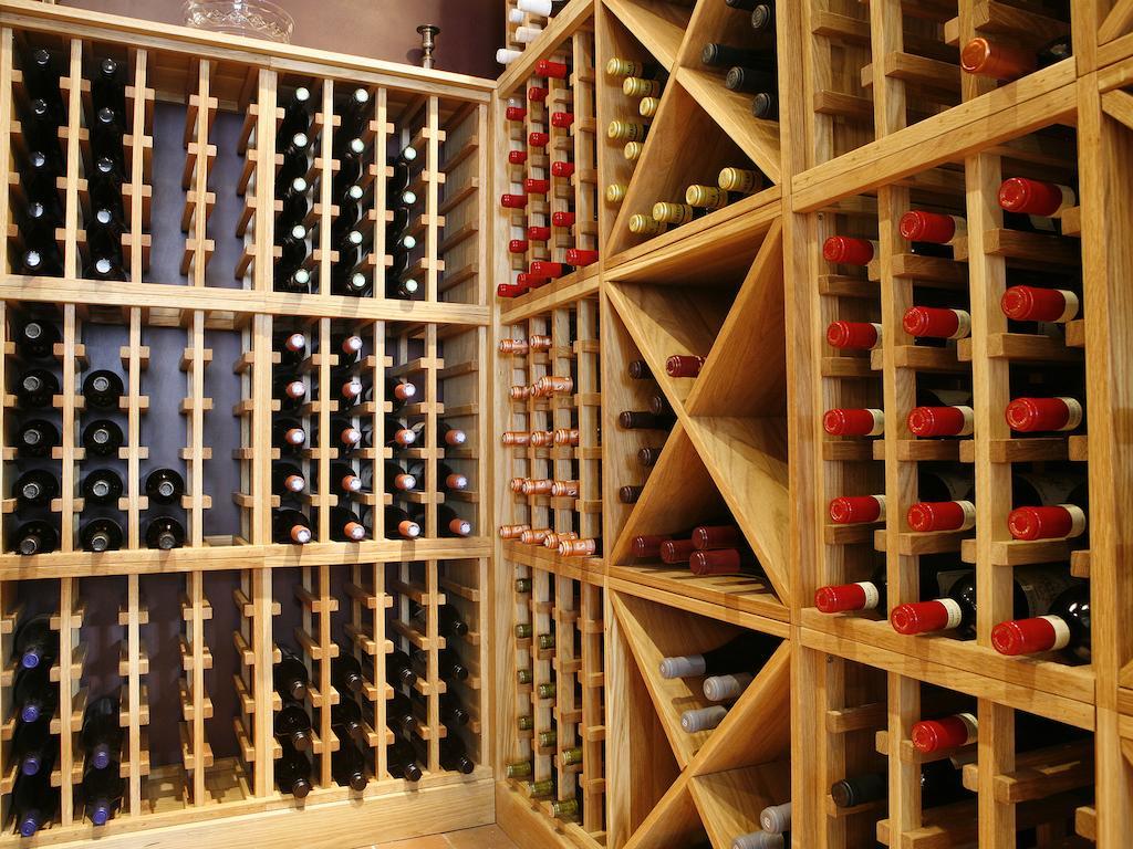 Montcalm Brewery Townhouse Hotel London Exterior photo The photo shows a wine cellar with wooden racks designed for storing wine bottles. The structure is divided into sections, featuring various compartments that hold the bottles in an organized manner. The bottles have different colors, with many red a
