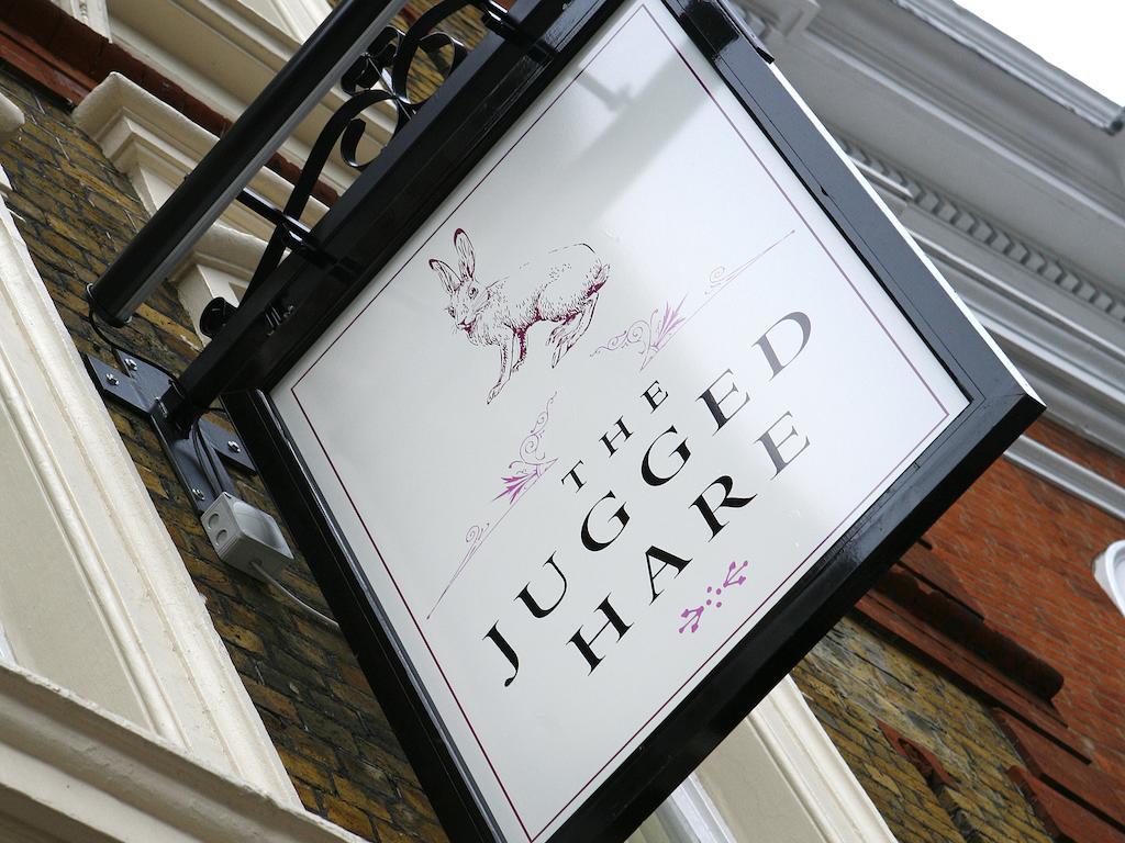 Montcalm Brewery Townhouse Hotel London Exterior photo The photo shows a hanging sign for a place called "The Jugged Hare." The design features an illustration of a hare, along with the name displayed prominently in bold letters. The overall aesthetic combines an elegant font with delicate floral accents